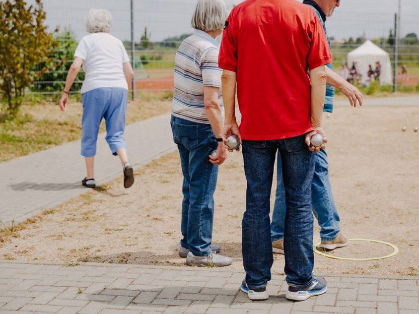 Das Bild zeigt Menschen, die im Sportpark Boule spielen.