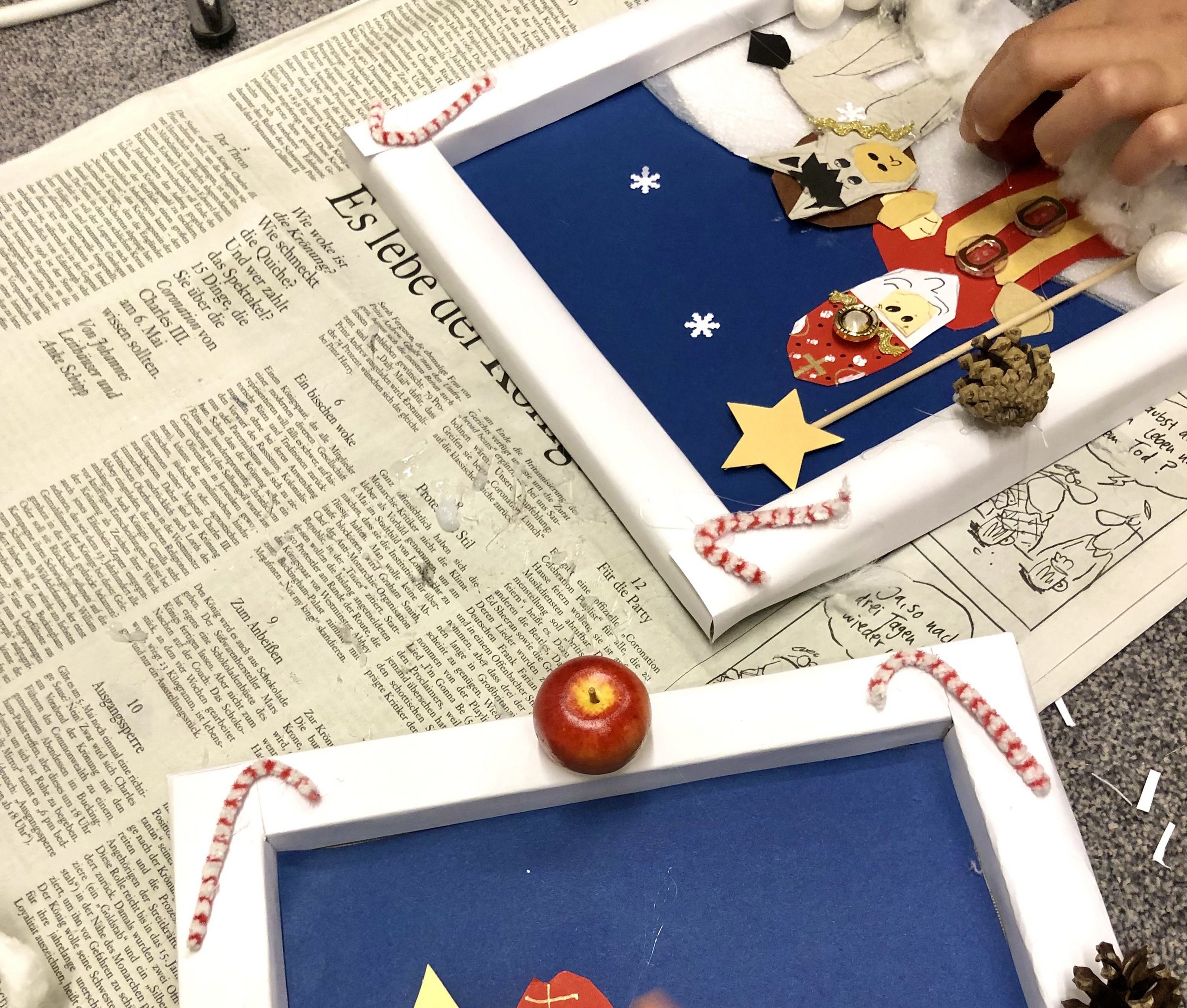 Weihnachtsbasteln mit Nicole Brys Auf dem Foto sind Hände eines Kindes zu sehen, das ein Nikolausbild bastelt.