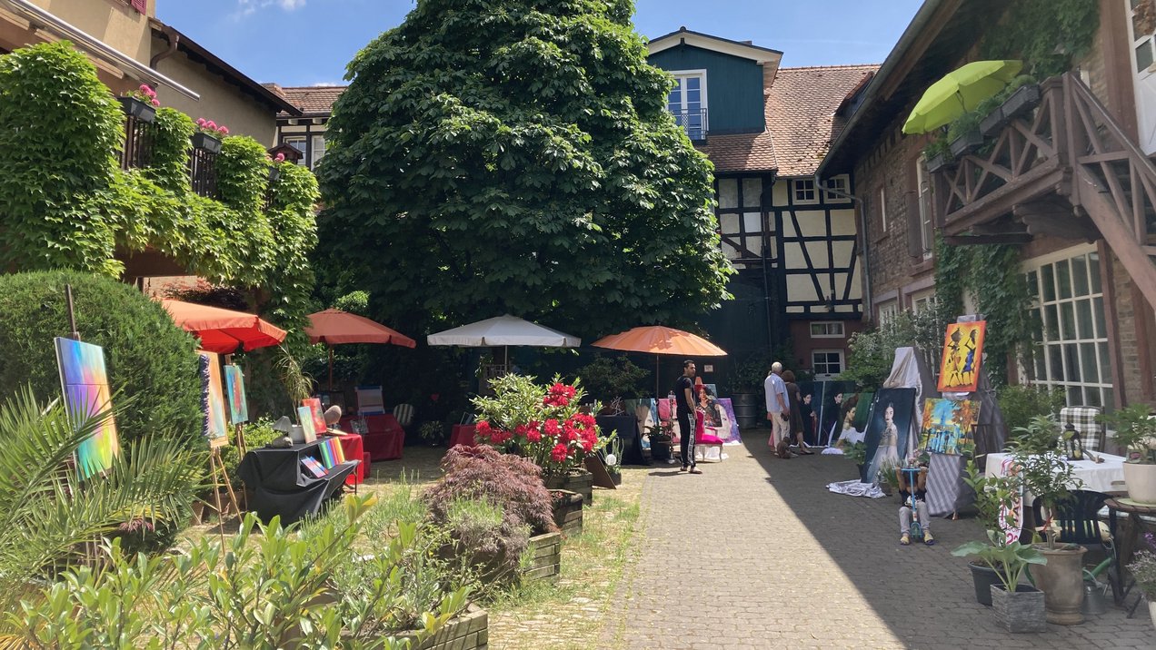 Das Bild zeigt Ausstellungen und bunte Sonnenschirme im Institut Garnier während der Kunsttage 2022.