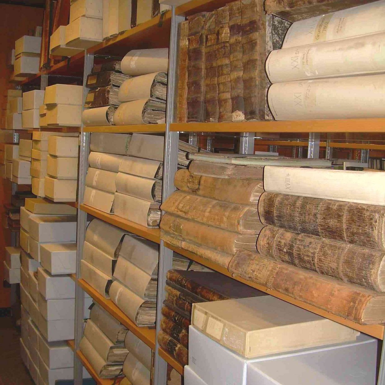 Das Bild zeigt alte Bücher der Stadt mit Eintragungen und Archivboxen.