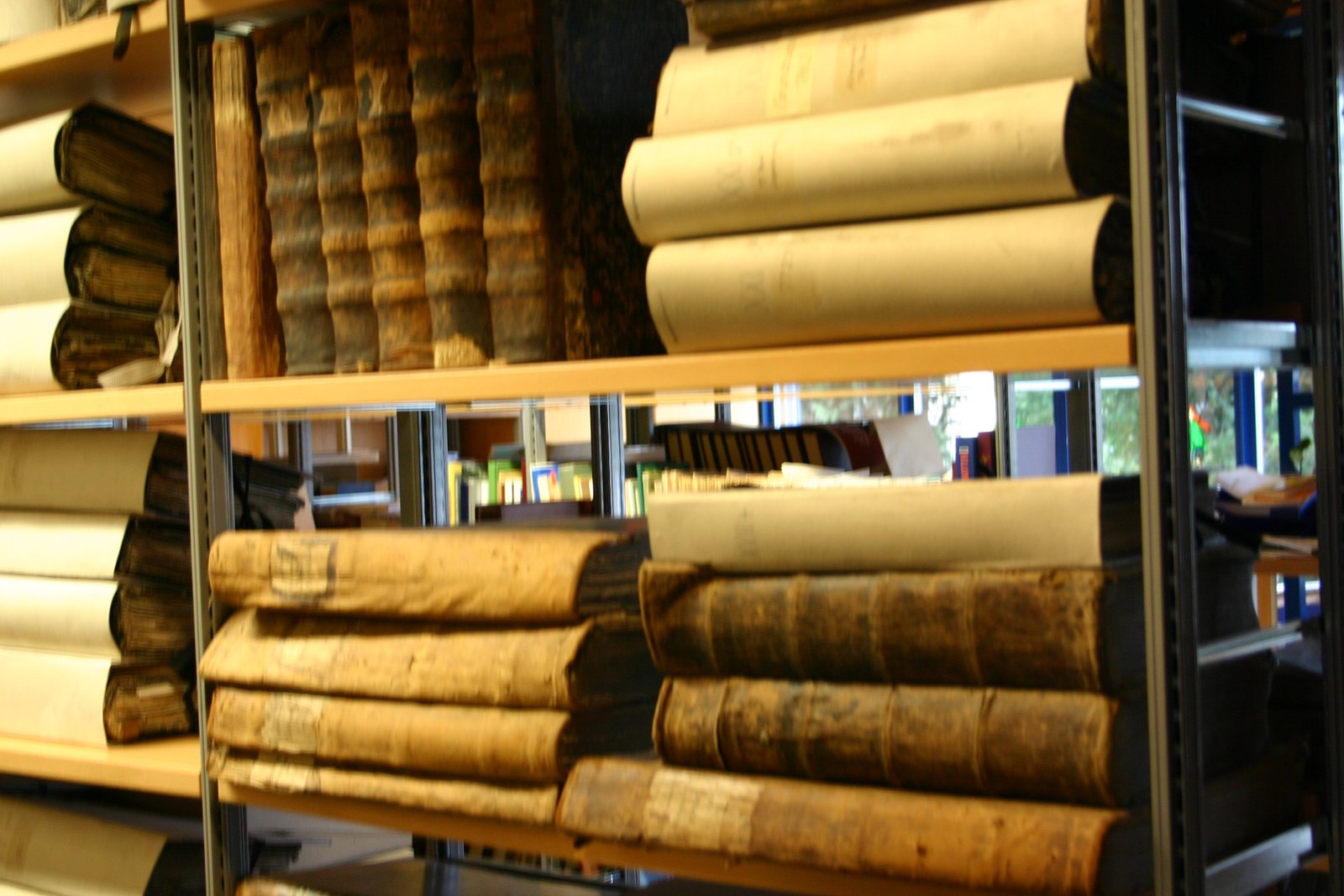 Das Bild zeigt alte gebundene Bücher der Stadt im Regal.