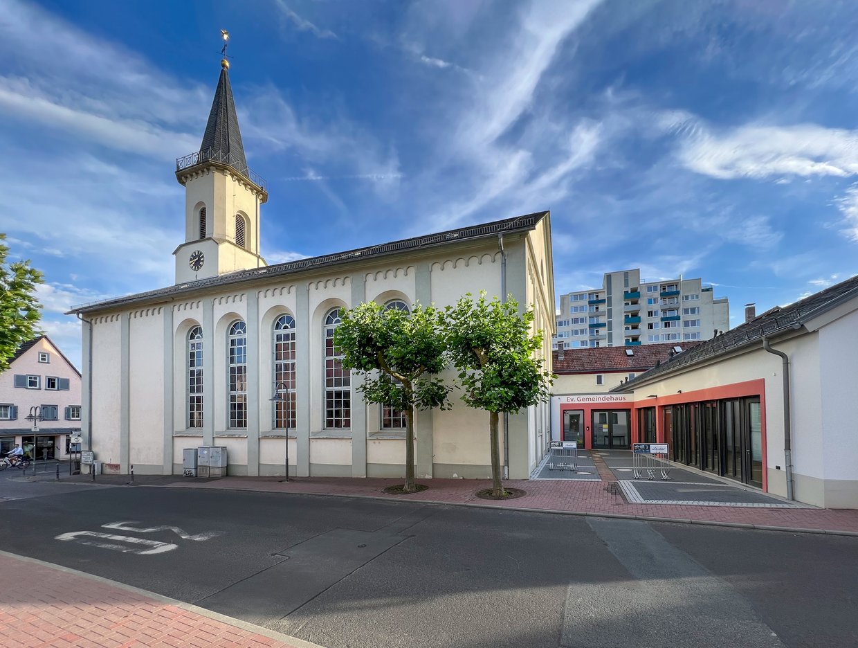 Auf der Darstellung ist eine Seitenansicht der Evangelischen Kirche Friedrichsdorf zu sehen.