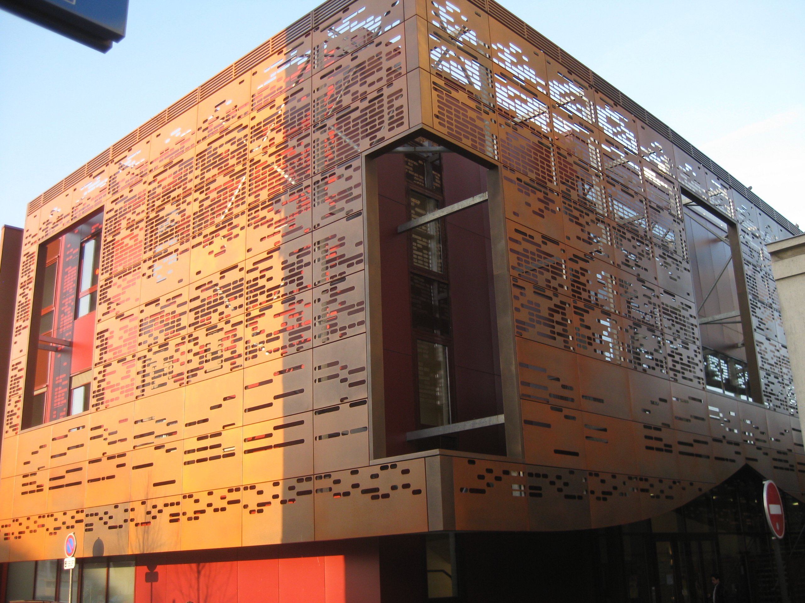 Auf der Darstellung ist das Konservatorium für Tanz und Musik in Houilles zu sehen, das mit Platten verkleidet ist, die aussehen wie Noten eines Leierkastens.