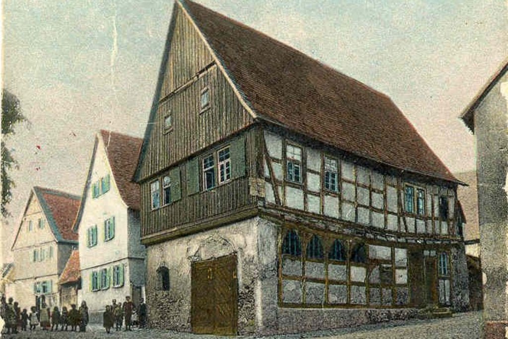 Das Bild zeigt eine historische Postkarte mit der Ansicht des Alten Rathauses in Burgholzhausen.