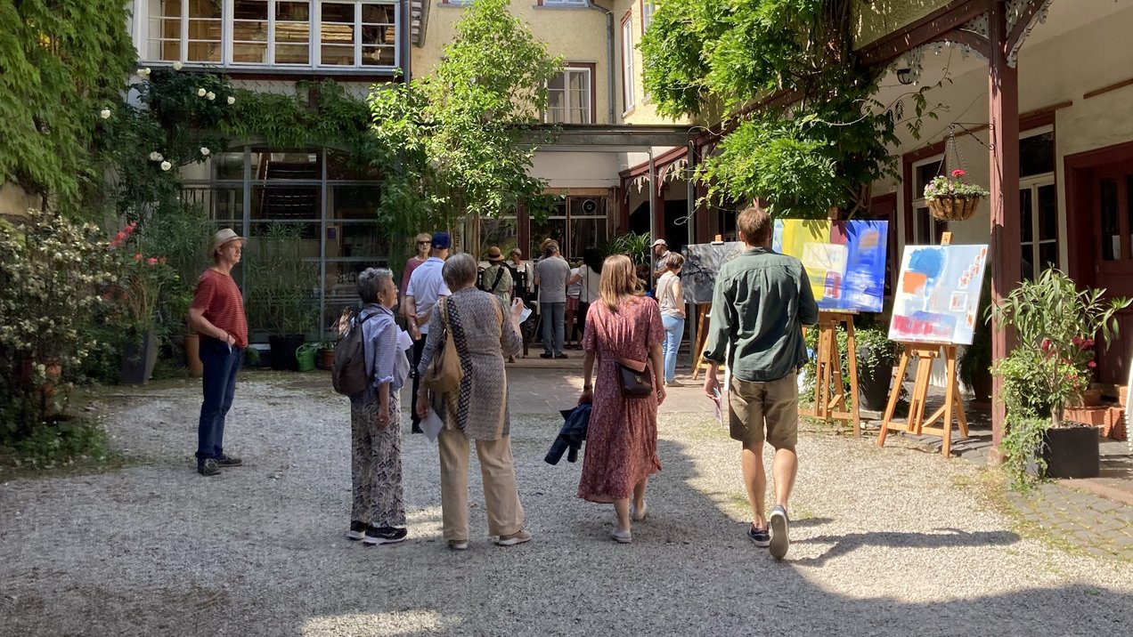 Das Bild zeigt Besucherinnen und Besucher bei einer Ausstellung in einem Innenhof während der Kunsttage 2022.
