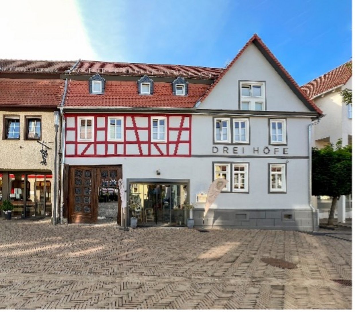 Auf der Darstellung ist die Gebäudefront des Hotels Drei Höfe zu sehen.