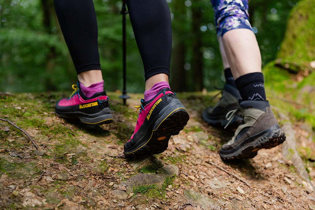 Auf der Darstellung sind die Füße von zwei Personen in Wanderschuhen zu sehen.
