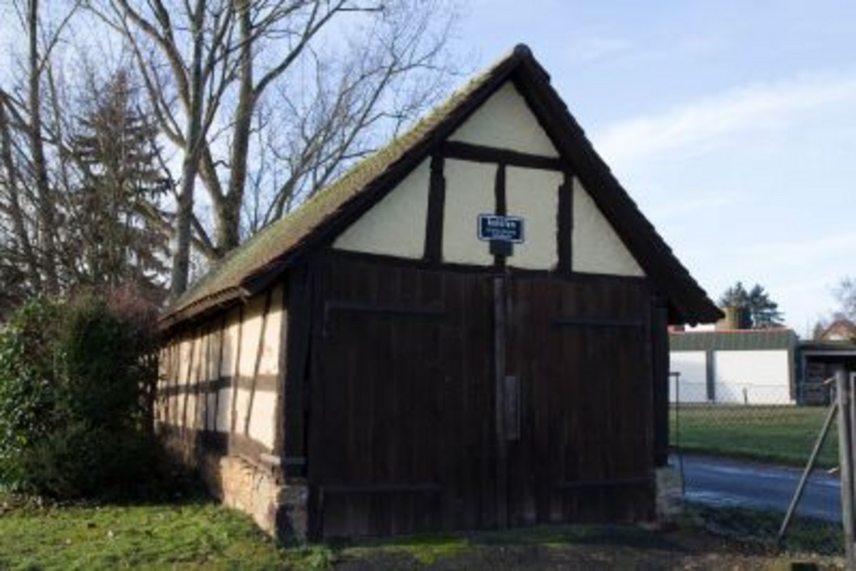 Auf der Darstellung ist der Aulofen, ein kleines Fachwerkgebäude, zu sehen.