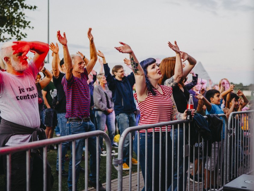 Menschen tanzen vor einer Bühne