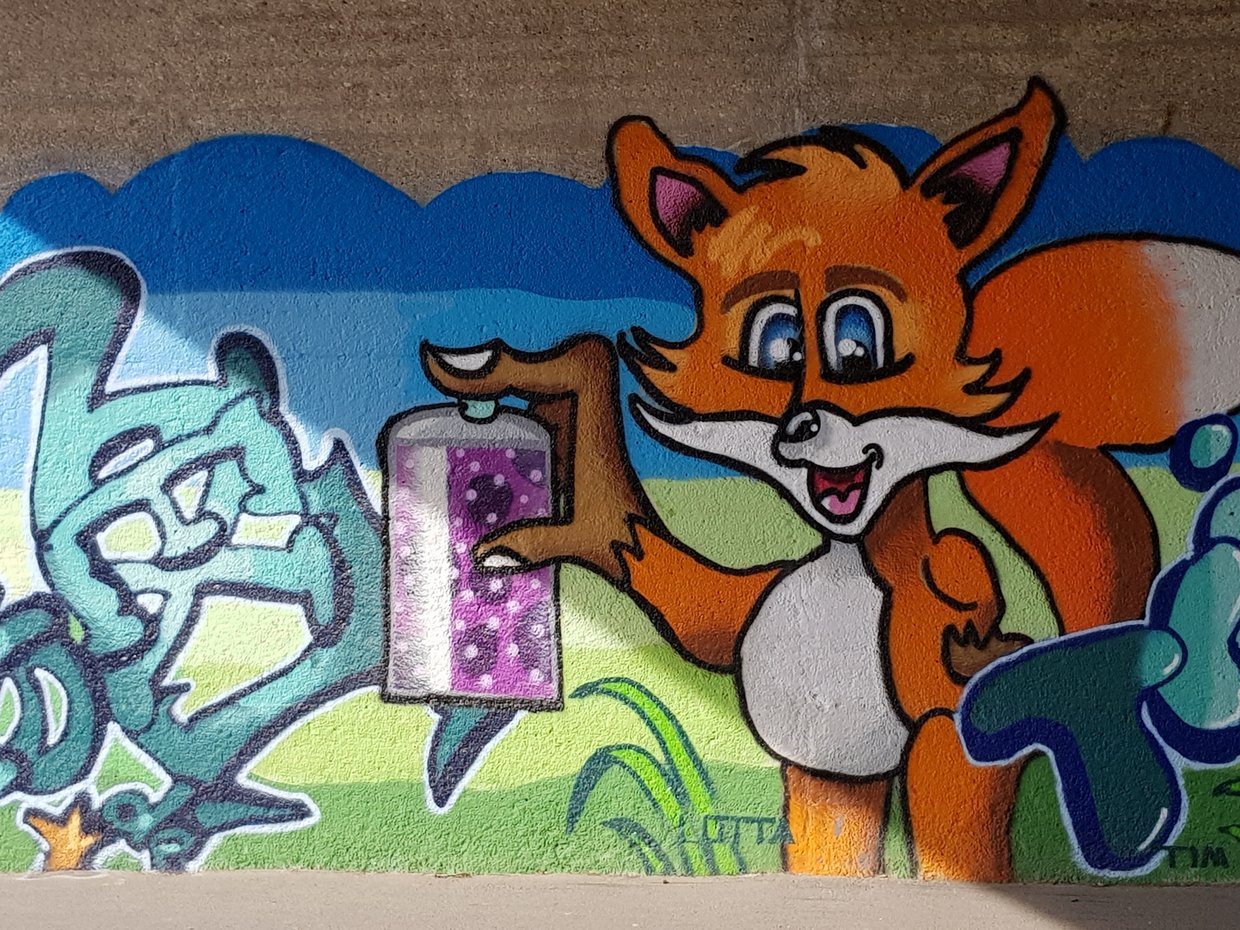 Auf der Darstellung ist ein buntes Graffiti in Form eines Fuchses mit Sprühdose in der Pfote zu sehen.