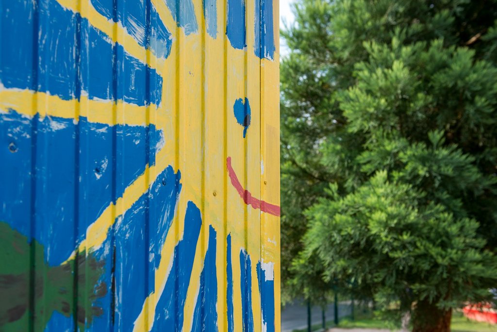 Auf der Darstellung ist eine gemalte Sonne an einer Hüttenwand zu sehen