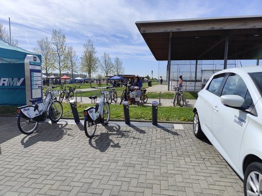 Das Foto zeigt die Mobilitätsstation am Sportpark Friedrichsdorf während des Friedrichsdorfer Fahrradtags. Zu sehen sind flux-Leihfahrräder an der Station sowie ein Carsharing-Fahrzeug, das im Rahmen des Aktionstags präsentiert wurde.