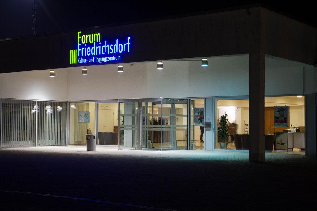 Auf der Darstellung ist der beleuchtete Eingangsbereich des Forums Friedrichsdorf zu sehen.