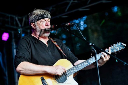 Auf dem Bild ist der Musiker Paddy Schmidt mit Gitarre zu sehen.