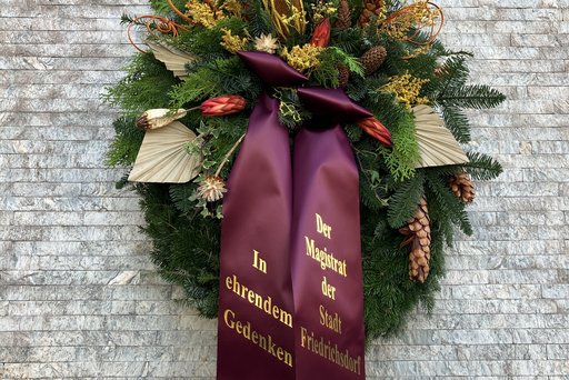 Kranz zum Gedenken am Volkstrauertag hängt am am Denkmal auf dem Friedhof in Friedrichsdorf