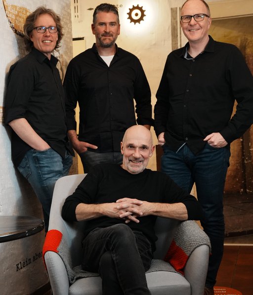 Auf dem Bild sind die drei Musiker von MiTabo sowie im Sessel sitzend Stephan Kilanowski zu sehen..