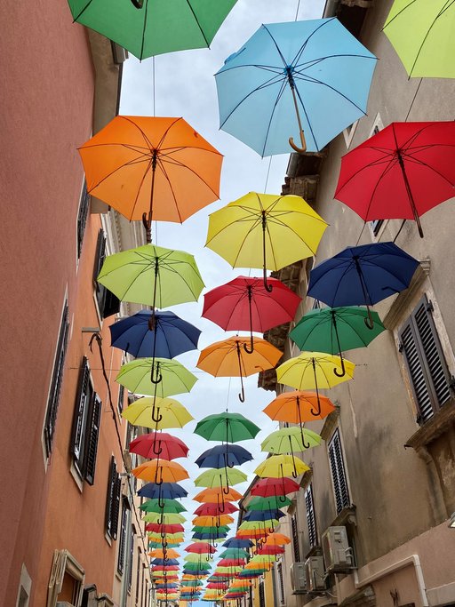 Bunte Regenschirme aufgespannt über einer Altstadtgasse